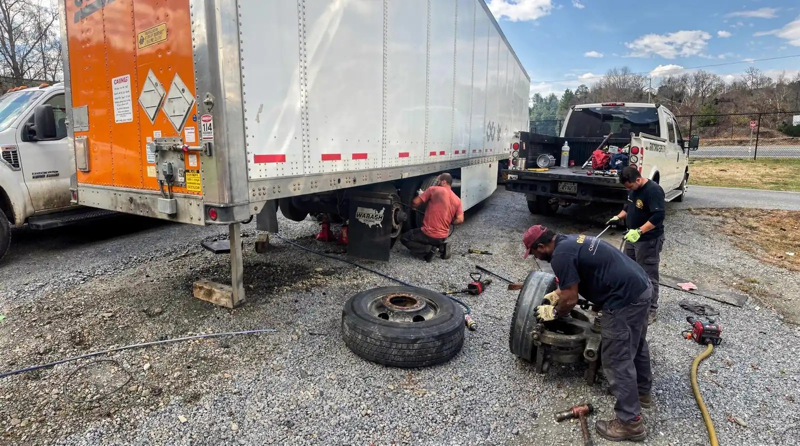 CPA Truck and Trailer Services crew servicing a semi trailer wheel hub and tire roadside with a mobile service truck parked nearby